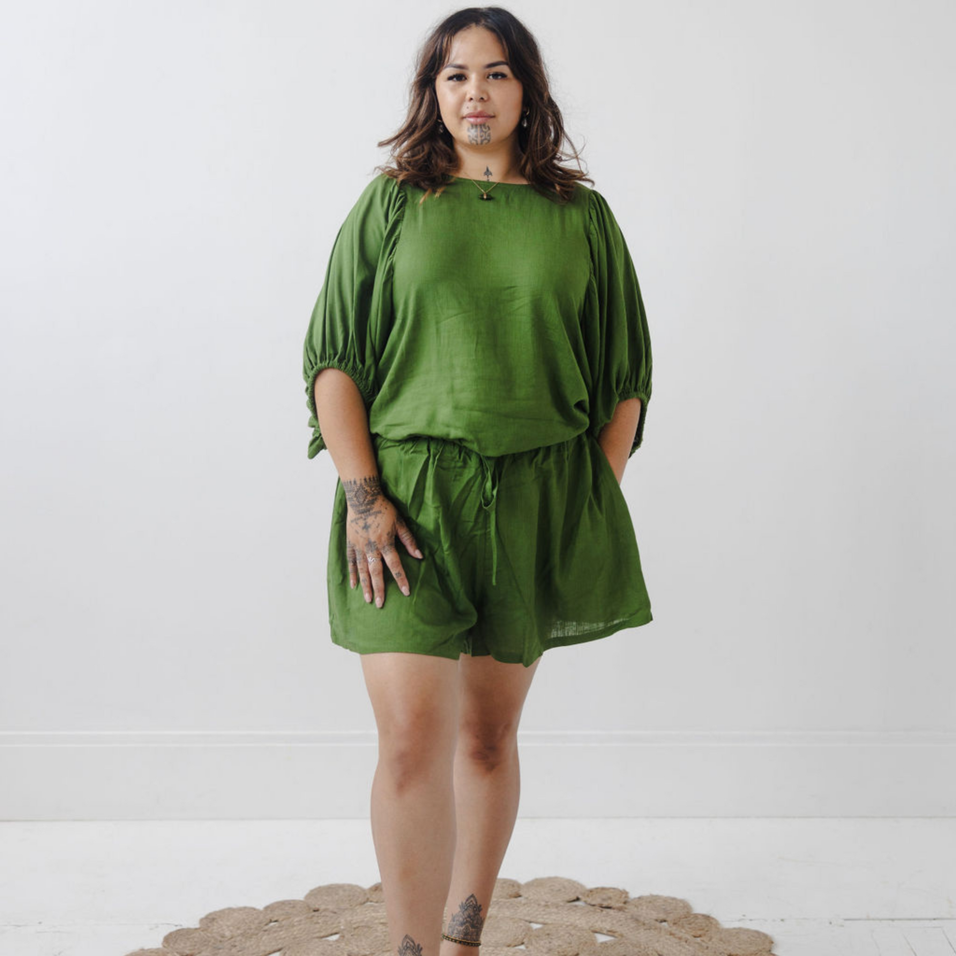 Jonique Oli, founder of Waiapu Road, wearing kapua top and shorts in olive