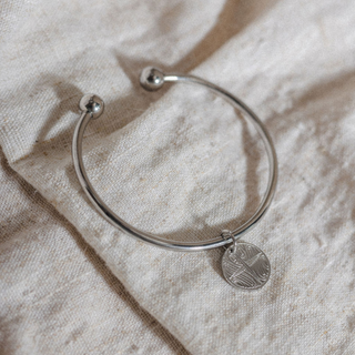 Silver Kāpehu Whetū Bangle laid flat on linen
