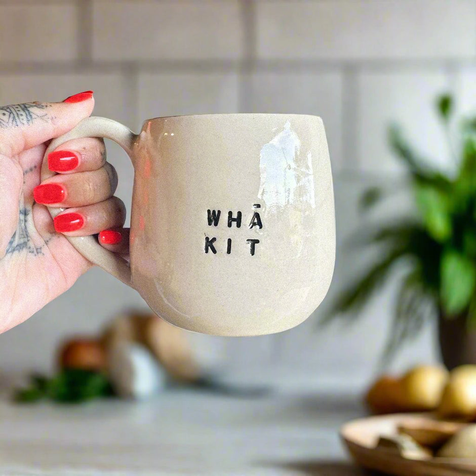 Wha kit plain mug being held in a kitchen